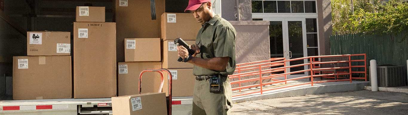 Livreur professionnel effectuant son suivi de tournée à l'aide d'un terminal informatique mobile